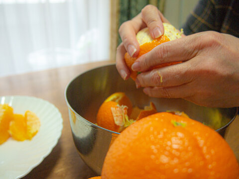 オレンジの皮むき　女性の手