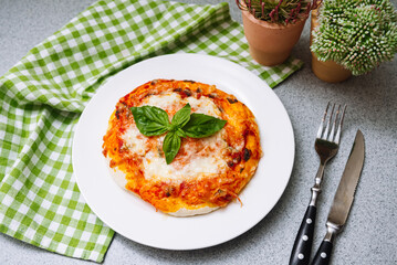 Homemade Margherita pizza with cheese, tomato sauce and basil leaf with crispy crust.