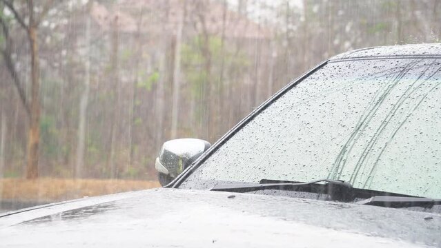Slow motion and close up of a carglass while it&rsquo;s raining