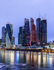 Fototapeta na wymiar Moscow City International Business Centre skyscraper buildings with panoramic windows night view. Moscow City at night. Lights are reflected in the river