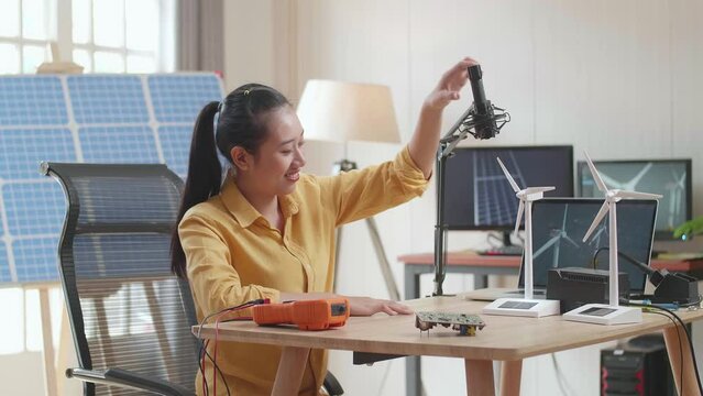 Asian Woman Being Happy Succeed Testing The Wind Turbine While Working With Laptop Next To The Solar Cell At The Office
