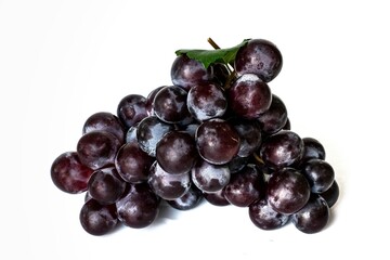 A large bunch of sweet dark red grapes close-up isolated on white background.