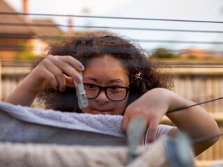 Girl hanging laundry in backyard
