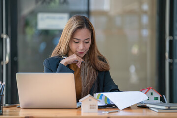 Real estate agent working with laptop at table in office