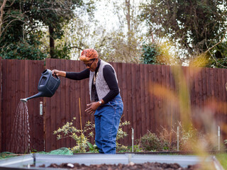 Woman watering plants in backyard