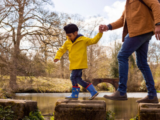 Father with son on stepping stones on lake