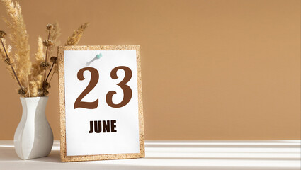 june 23. 23th day of month, calendar date.White vase with dead wood next to cork board with numbers. White-beige background with striped shadow. Concept of day of year, time planner, summer month