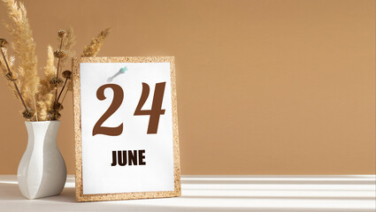 june 24. 24th day of month, calendar date.White vase with dead wood next to cork board with...