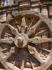 Fototapeta na wymiar The famous stone chariot wheel engraved in the walls of historic Sun temple in Konark (Odisha, India), a world heritage site.