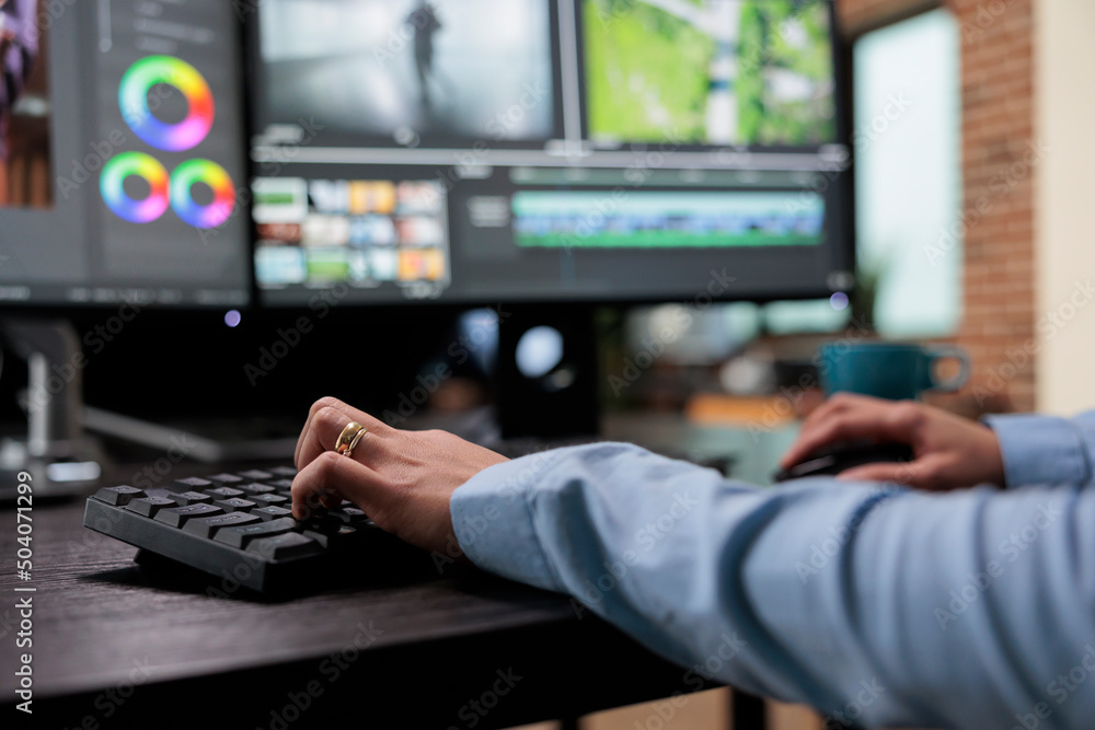 Poster close up shot of digital video editor sitting at multi monitor workstation desk while working on mov