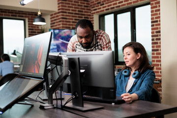 African american company coworker standing near production department team leader desk while discussing. Digital graphic artist with colleague talking about future of project.