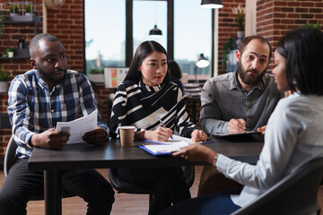 Diverse businesspeople interviewing african american candidate discussing cv resume recruiting employer for human resources job in startup company office. Concept of hiring process