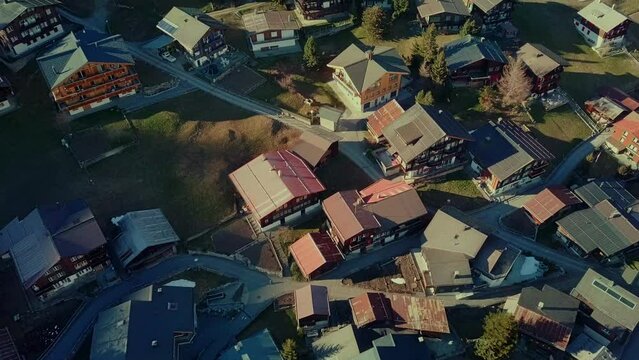 Aerial moving over chalets in Swiss village of M&uuml;rren in Alps mountains