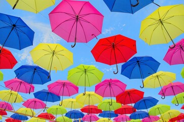 Fototapeta na wymiar Yakutsk, Sakha Yakutia / Russia - july 7 2019: Many multi-colored umbrellas background. Colorful umbrellas floating above the street. Street decoration. Umbrellas on air. Flying umbrellas.