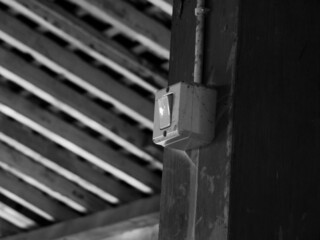 black and white photo of a light switch in a traditional wooden house