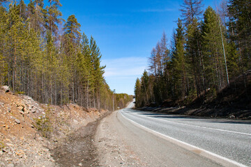 Fototapeta na wymiar Highway in the Urals. A highway in the Urals in the Sverdlovsk region, running through forests.