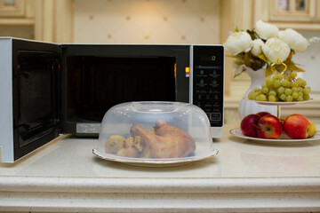A plate of food in the microwave covered with a lid. The benefits and harms of microwave radiation...