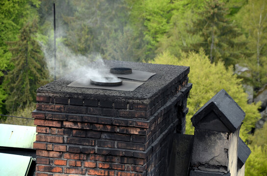 a dirty chimney in which coal is heated. soot is everywhere on the brick masonry. in the spring in the woods at the cottage. Victorian style. ecological way of heating houses and flats