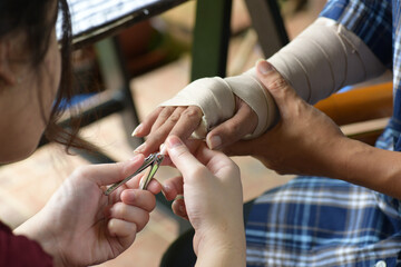 Women take care of their nails with Asian man gets accident to fracture broken arm recuperate, a...
