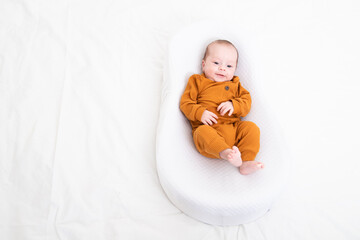 The baby is lying in a cocoon of copy space . The baby is 0-3 months old. A contented infant. An...