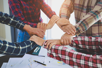 A diverse group of people connects their hands as a supportive sign expressing a sense of teamwork....