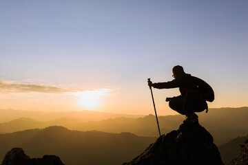 Silhouette of female climber on the top of the mountain, trekking,  success, competition and leader concept.
