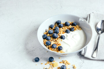 Fototapeta na wymiar Yogurt with muesli and berries on a gray background.