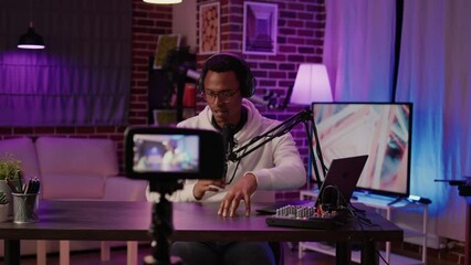 African american influencer recording podcast using digital video camera for vlog post on social media. Content creator streaming live internet show from home studio using professional equipment. - Powered by Adobe
