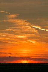 Amazing orange summer sunset with spectacular clouds on sky. Great landscape good to be used as background.