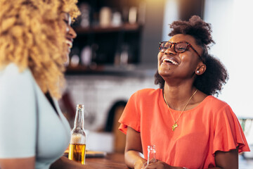 Beautiful young people in casual clothes are resting with bottles of drink, talking and smiling