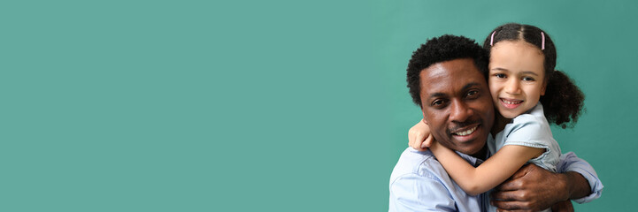 Obraz premium Portrait of little African-American girl hugging her father on green background with space for text