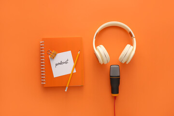 Microphone, headphones, paper with word PODCAST and notebook on color background