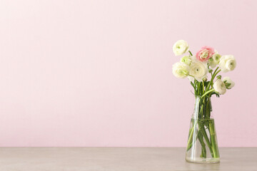 Glass vase with beautiful ranunculus flowers on table