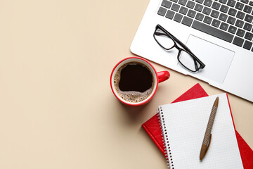 Cup of coffee, notebooks, eyeglasses and laptop on color background, closeup