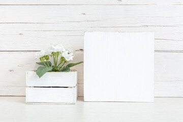 White square sign on the table with a flower.