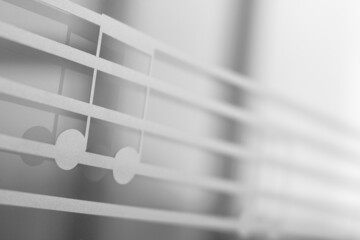 Close up of a window decorated with music note signs. Black and white. High key photo. Copy space.