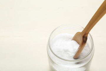 Jar with baking soda on white wooden background, closeup