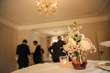 Flowers as a decoration on a table. champagne reception inside. receive guests