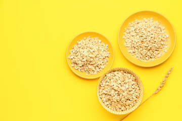 Plates of raw oatmeal on yellow background