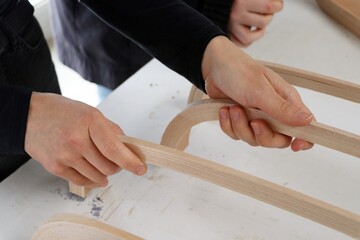 Woman's hand designing furniture from pieces of wood