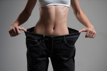 Slim waist. Oversized womans pants trousers in weight loss concept. Woman in dieting concept with big jeans.