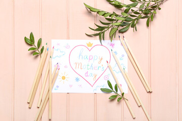Card with text HAPPY MOTHER'S DAY, pencils and plant branches on pink wooden background