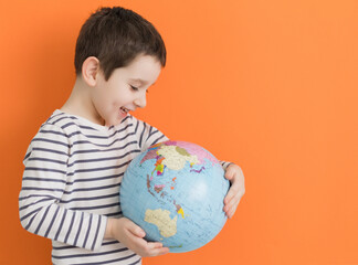 Boy with globe on orange background