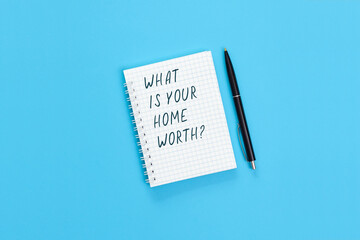 The text What is your home worth is written on a notebook page