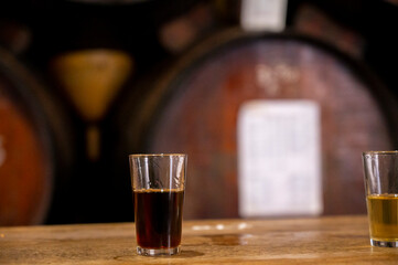 Tasting of different sweet wines from wooden barrels on old bodega in central part of Malaga,...