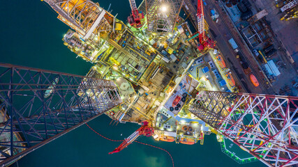 Aerial top view jack up rig under maintenance at night with blue ocean, Aerial view jack up rig...