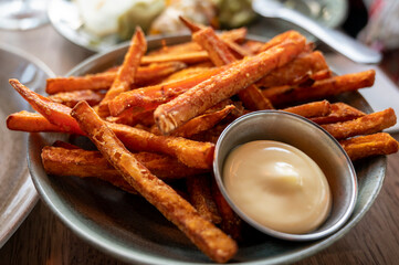 Bowl with deep fried sweet potato chips served with mayonnaise sauce