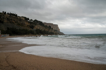 Fototapeta na wymiar Stormy sea, high waves on yellow sandy beach in Cassis, Provence, France