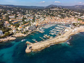 Panoramic aerial view on cliffs, blue sea, beach, houses, streets and old fisherman's harbour with lighthouse in Cassis, Provence, France