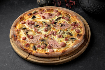 Tasty pizza with sausages ham and mushrooms on table